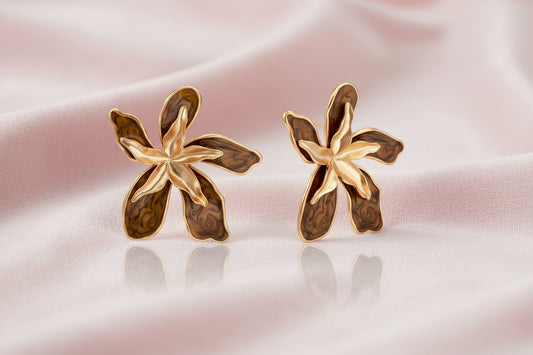 Gold-plated brass flower earrings with brown tortoiseshell enamel petals on cream background