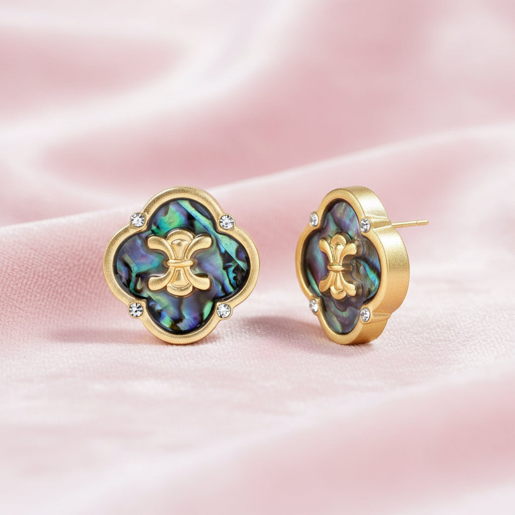Gold quatrefoil stud earrings with iridescent abalone shell inlay and fleur-de-lis center, accented by four crystals