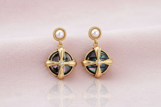 Gold-plated drop earrings with iridescent abalone shell and pearl studs in geometric cross design