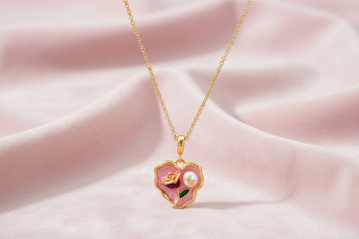 Heart-shaped pendant with pink enamel, rose design, freshwater pearl flower, and gold scalloped frame on delicate chain