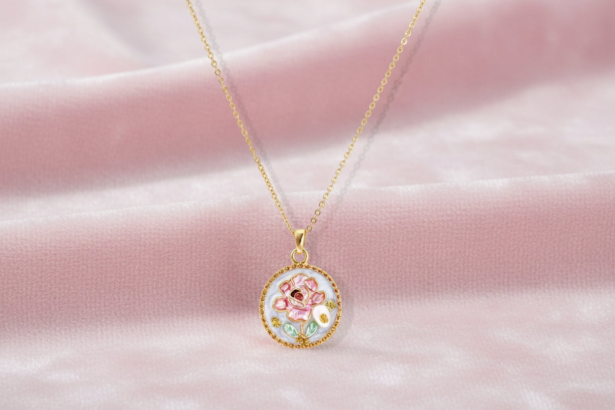 Gold-plated circular pendant with pink enamel rose, pearl background, and delicate beaded border on chain