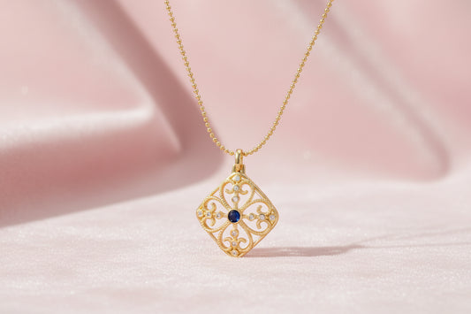 Gold filigree pendant with quatrefoil design, deep blue lapis lazuli center, clear crystal accents on ball chain