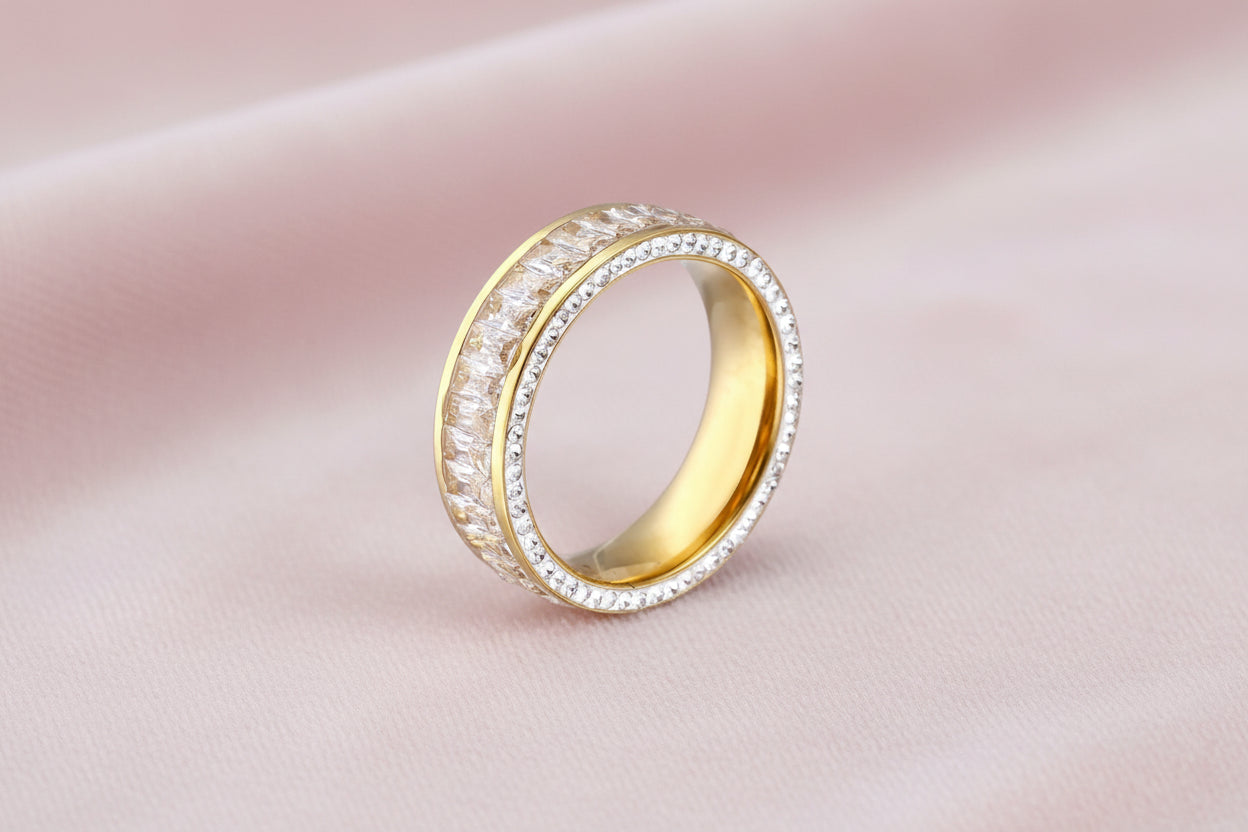 14K gold-plated ring with dual rows of clear baguette and round zirconia stones on cream background.