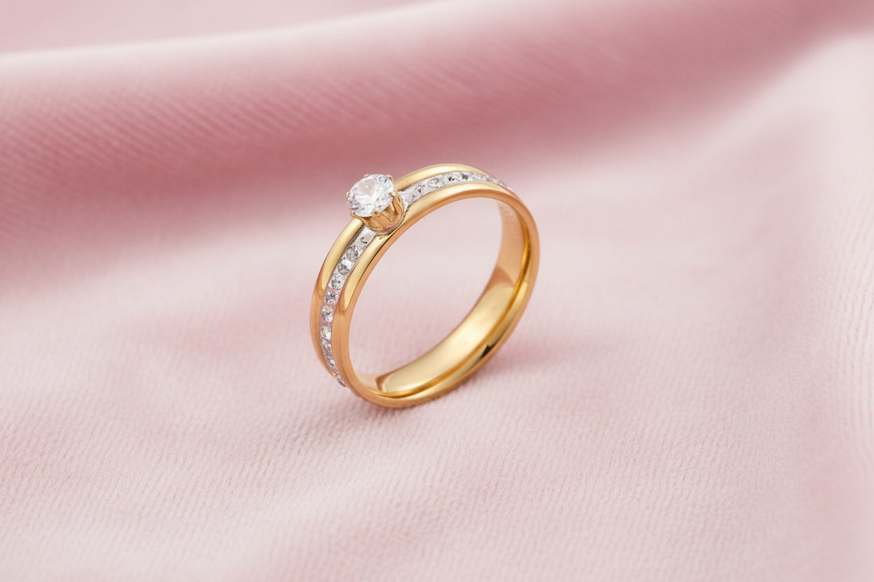 Gold-plated double-band ring with center rhinestone solitaire and channel-set stones on white background