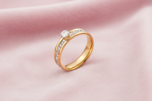 Gold-plated double-band ring with center rhinestone solitaire and channel-set stones on white background