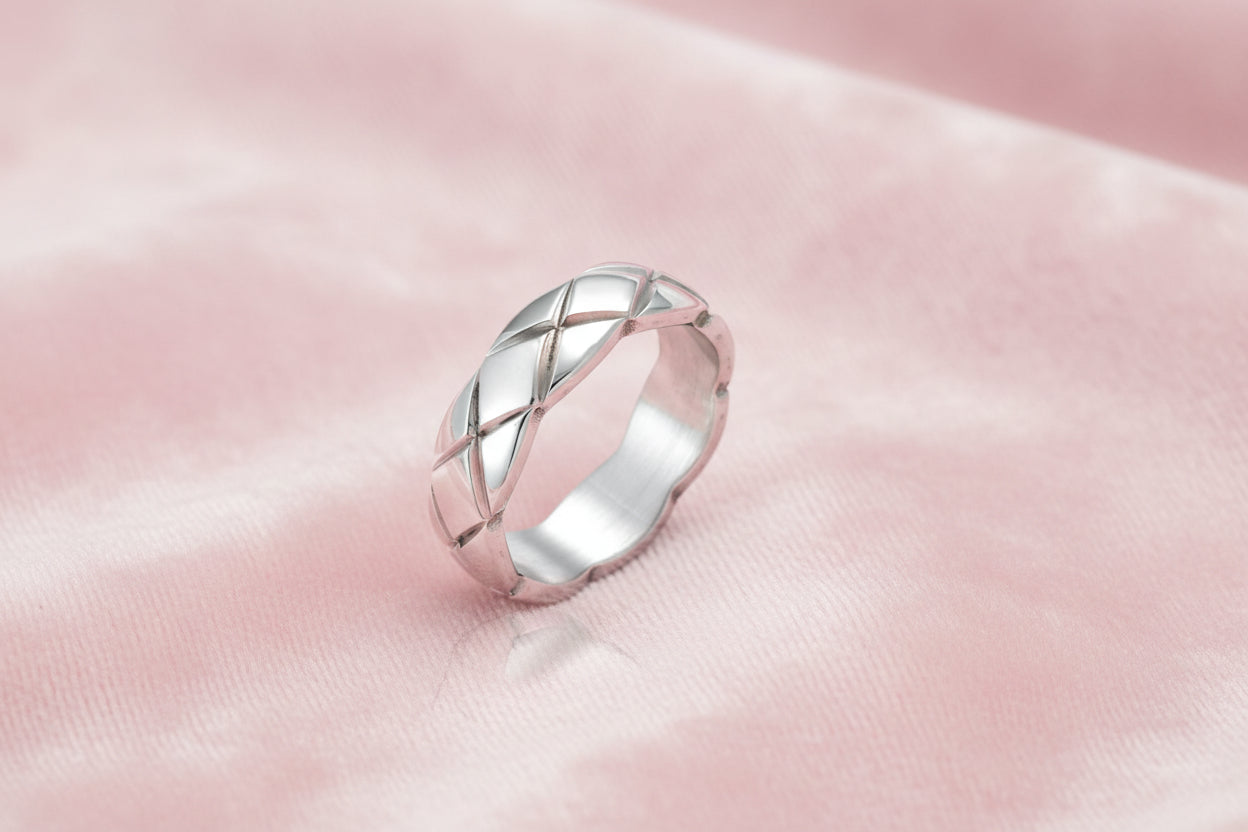 Braided stainless steel band ring with geometric interwoven strands in brushed silver finish on white background