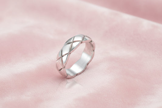 Braided stainless steel band ring with geometric interwoven strands in brushed silver finish on white background