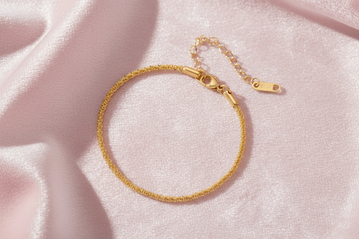 Delicate 18K gold-plated stainless steel bracelet with textured beaded chain on cream background