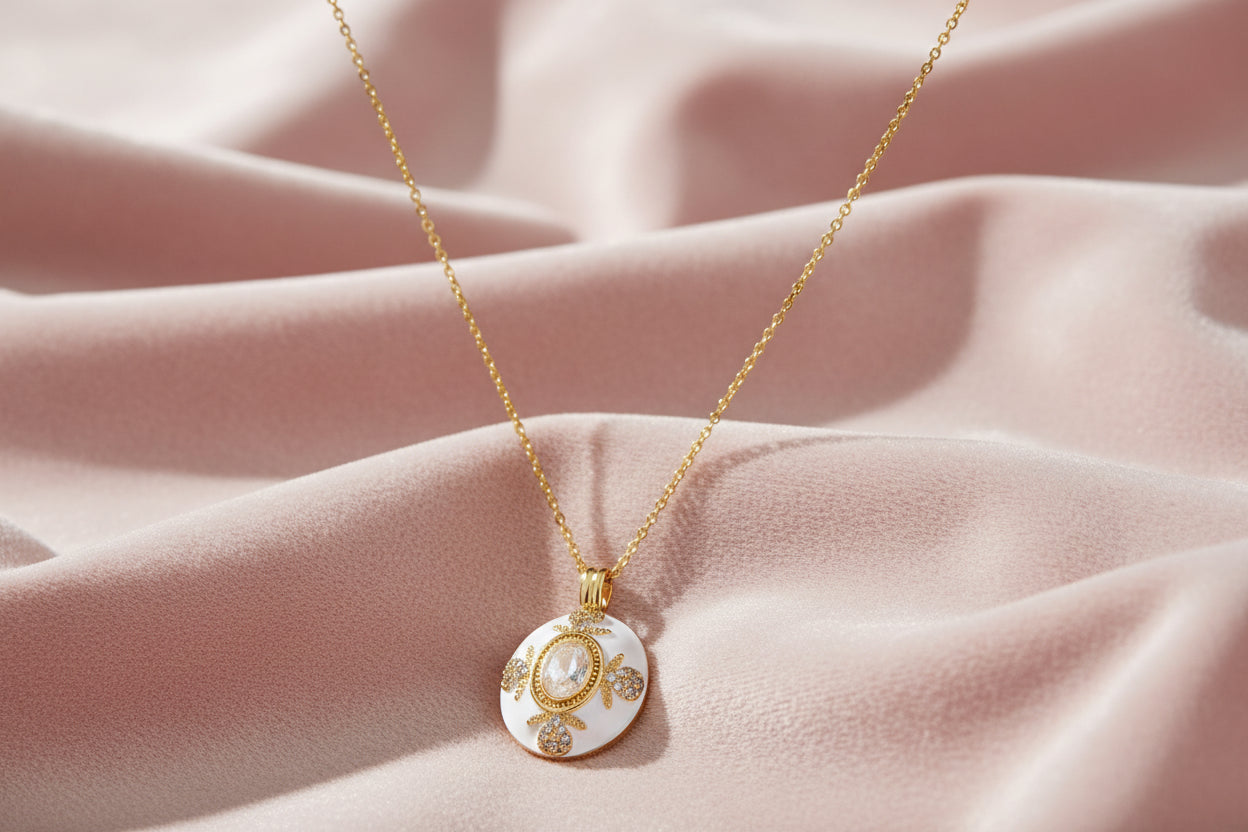 Gold-plated necklace with circular white enamel pendant featuring central zirconia stone and ornate decorative details