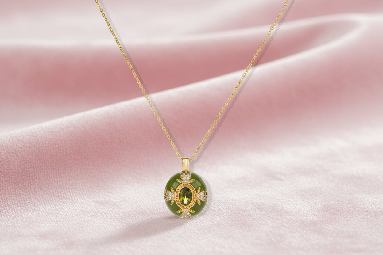 Gold-plated pendant necklace with green enamel background and oval olive cubic zirconia center stone with crystal accents.